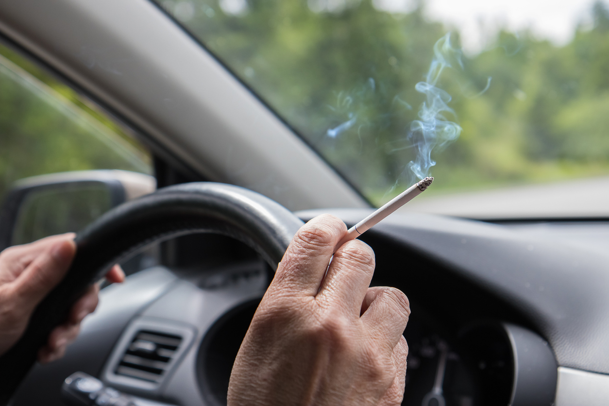 Воняет в машине. Машина пропахшая табаком. Курение в автомобиле. Сигареты в салоне автомобиля. Дым сигареты в руке за рулем.